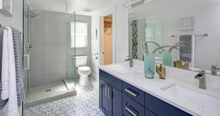 Wide Bathroom with blue vanity cabinet and patterned tile flooring